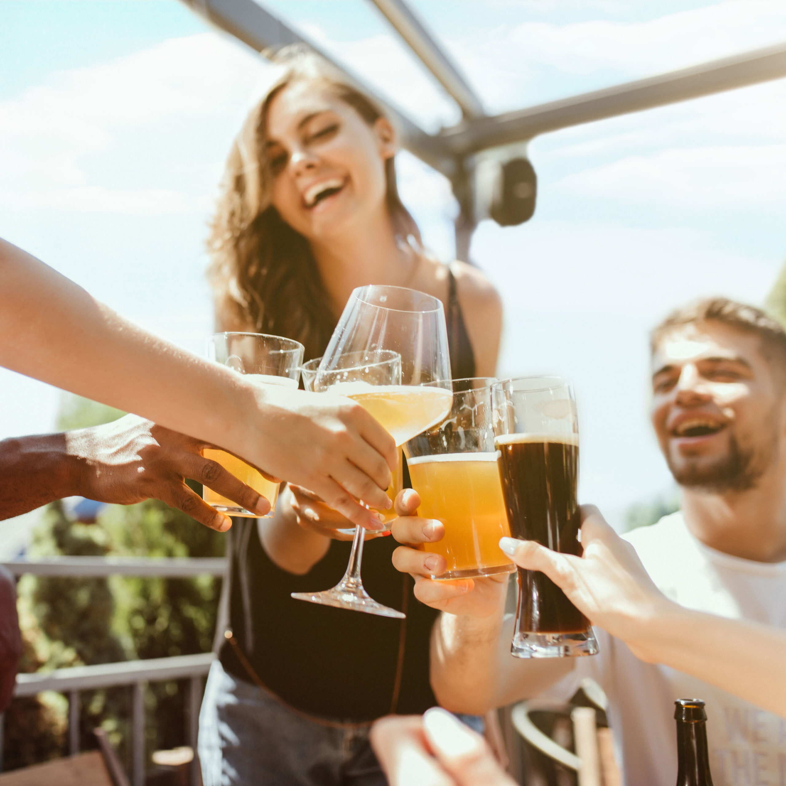 Young group of friends drinking beer and celebrating together